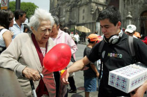 在墨西哥首都墨西哥城的索卡洛捷運車站附近，一男子陪同母親外出。5月11日是母親節，許多墨西哥年輕人會選擇在這一天帶上鮮花和禮物，陪伴母親過一個快樂的節日。