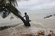 （圖）在南太平洋島國吉里巴斯，來自Betio村的Pita Meanke站在一棵樹旁，那次巨大的浪潮，衝垮了防波提，摧毀了他的家。