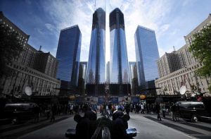 人們從正在建設的紐約世貿中心1號樓（中右）下經過，旁邊高樓的玻璃幕牆反映出世貿中心1號樓的影像（中左）。 