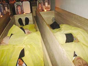 一些韓國人躺在“棺材學院”的棺材中體驗死亡。