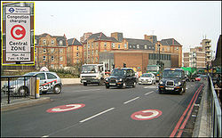 （圖）倫敦實施交通擁擠費，以紓解市中心日益擁擠的車流。圖中路面上標示“C”的紅色圓形是告知駕駛人已經進入擁擠費的收費區域