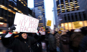 2月20日，在位於美國紐約曼哈頓的《紐約郵報》門前的抗議活動中，一名民權人士手舉標語牌高呼口號。