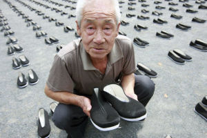 87歲的中國被擄勞工倖存者李鐵錘老人顫抖地捧起一雙布鞋，雙眼模糊