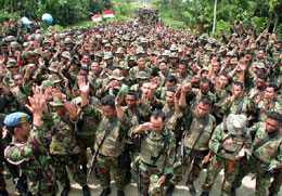2002年12月10日，印尼政府軍士兵在從亞齊特區撤出前一同歡呼。