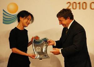 2010年4月22日，在韓國首都首爾，中國演員周迅（左）從聯合國副秘書長、環境規劃署執行主任阿希姆·施泰納手中接過獎盃。