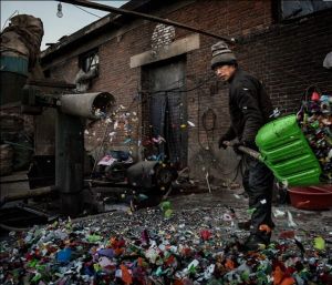 一名婦女站在漫天紛飛的輕型垃圾下