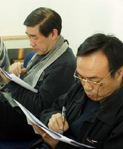 評審顧錚（左）和鮑昆給候選攝影師投票