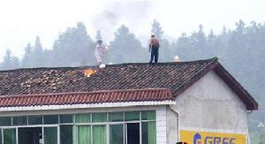 2010年9月10日上午，江西省撫州市宜黃縣鳳岡鎮在拆遷期間發生一起燒傷事件，拆遷戶三人被燒成重傷，疑為自焚。圖為拆遷戶家人羅志鳳和葉忠誠在樓頂。
