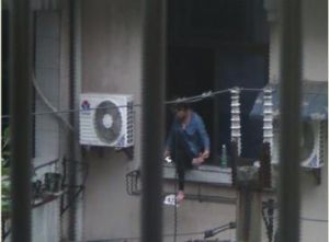 女子一直坐在窗台上。視頻截圖