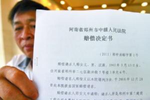 鄭安義向記者展示賠償決定書