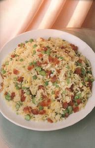 菜 名： 玉蘭炒飯 主 料： 白飯2碗，雞蛋2隻，芥蘭梗3兩（約120克），臘腸2條，蒜頭2瓣（切碎），鹽或魚露適量，油3湯匙。 做 法： 1、芥蘭梗切粒，放滾水中焯熟，瀝乾待用。2、臘腸切粒，爆香後盛起待用。3、雞蛋攪散。4、燒熱油，放入蒜茸及雞蛋炒至半熟，加入白飯、芥蘭及臘腸炒勻，用鹽及魚露調味即成。 備 註： 1、爆臘腸不必用油，臘腸受熱自會滲出油分。2、雞蛋必須在半熟時即加入白飯，否則太熟時不易與白飯混合。