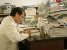 一位教師在教研室認真批改學生作業