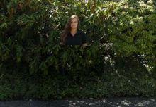 穿著量子隱形衣的人站在樹叢前