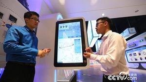 王金靈向吳鵬介紹智行公交手機APP能給百姓乘車帶來哪些方便