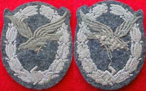 空軍無線電操作員/航炮手章布製版本像大多數其他德國空軍Luftwaffe   資格徽章一樣也規定軍官為金屬絲手工刺繡版本，士官為機器棉線版本。各式布製版本通常縫製在藍色/灰色的標準基布上。