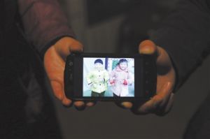 2013年5月2日河北平山縣兩河村，兩位傷心的母親用手托著手機里兩個孩子生前的照片，小怡（左）和小凝。