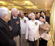 歐初（中）向來賓介紹自己的書畫作品