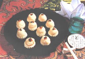 菜 名： 百花釀豆腐 主 料： 絹豆腐2盒，蝦茸200克。 配 料： 青椒末、香菇末、紅椒末、鹽、味素、生粉各適量。 做 法： 豆腐用模具印成花邊圓體片，蝦茸加鹽、味素調味後釀在豆腐上，待做好後在表面放少許紅椒末、青椒末、香菇末加以點綴，蒸5分鐘，勾玻璃薄芡即可。 特 點： 鮮嫩味美。