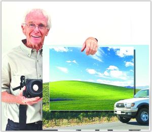 攝影師查克·奧里爾手持“視窗”XP桌面圖片站在照片拍攝地