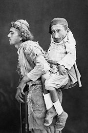 圖為累范特一位盲人男子背著一位畸形人，拍攝於1890年之前。