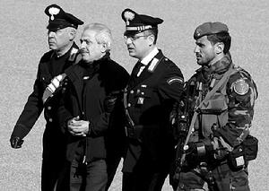 ，“恩德朗蓋塔”黑手黨集團“教父”帕斯夸萊&middot;孔代洛（左二）在警察的押送下走向直升機。