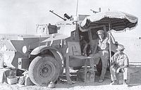 1940年7月26日在利比亞邊境的一次巡邏中，第11輕騎兵團的軍官停下時使用一把陽傘遮陽。旁邊是一輛莫里斯CS9（Morris CS9）型裝甲車