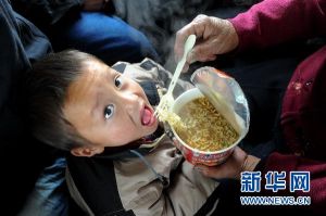 L160次列車上，一位乘客在餵孩子吃速食麵（1月21日攝）。新華社記者 郭晨 攝