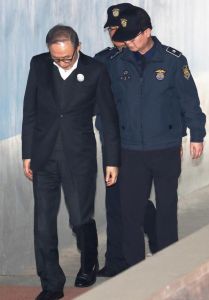 李明博被獄警攙扶進法院