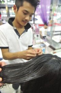 理髮師嘗試各種方法要把頭髮從強力膠中分離出來。