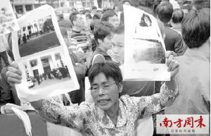 2009年11月11日一審時，死者嚴曉玲的母親林秀英手舉訴訟材料。