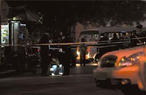 警方在報刊亭前尋找蛛絲馬跡