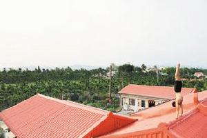 圖為他在屏東縣自家的屋頂上倒立。