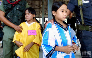 圖為2001年1月22日，第一次投降，約翰尼（右二）和盧瑟（左二）由泰國警方押護出席新聞發布會。