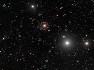受類星體（紅圈）的照射，科學家們發現了其旁邊的暗星系（綠圈）