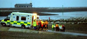 在英格蘭西北部莫克姆灣海灘，救援人員將遇難者遺體抬上一輛救護車。