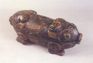 （圖）該盒子由蓋與盒身合成，兩頭雕刻成豬頭狀，身下雕踞伏四足，神態憨厚可掬，可以看出當時木器工匠們的巧妙構思和嫻熟技術。體現了戰國時期中國家具的藝術成就。