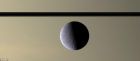 “卡西尼”號拍攝的土衛五的照片，背景是土星環面黑線和黑暗大氣。