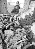 （圖）阿富汗戰爭引發大地震後，孩子們在一所坍塌的房屋裡發現了剩餘的炮彈