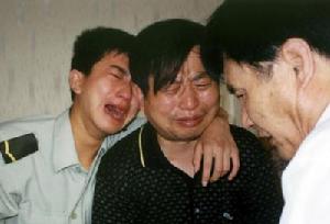 6月22日，15歲的雙胞胎姐妹唐文娟、唐秀娟和媽媽向吉平從恩施乘武航班機前往武漢，準備為當兵的哥哥唐雨露慶祝生日，不料母女3人在“6&middot;22”空難中全部遇難。6月24日，父親唐開旺(中)聞訊趕至武漢，悲痛至極，和兒子唐雨露(左)哭成了淚人。