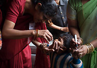 在印度烏塔拉坎德邦，衛生工作者正在接種小兒麻痹症口服疫苗。聯合國兒童基金會與當地宗教領袖、學校和大學攜手合作，在一些社區克服困難，推廣免疫計畫。