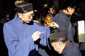 梳發師認真的為新晉道士佩戴偃月冠