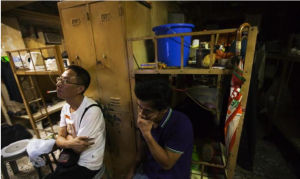 租客在床前的公共區域看電視，一個床位的租金為每月約1000元人民幣