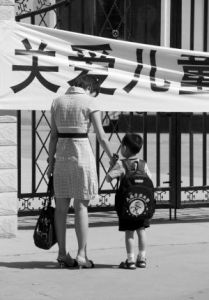 一位送孩子入園的家長在橫幅前駐足