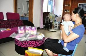 4個月大的小彤在媽媽懷裡哭鬧，桌上擺滿了她吃過的奶粉包裝盒