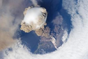 這張引人注目的照片展示了6月12日日本東北部千島群島的薩里切夫火山噴發。照片中最令人感興趣的並不是火山噴發本身，而是噴發時形成的一個帽狀雲。穿過上方雲層時，火山灰柱似乎戴上了一頂光滑的白帽子，從而形成照片中的帽狀雲。