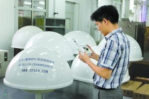 工程師手拿純自主研發的北斗探空系統的探空儀進行測試