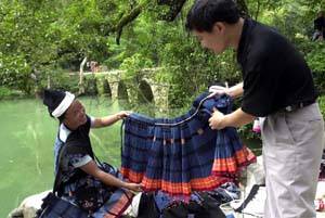 這位瑤族婦女向遊客介紹手工刺繡裙