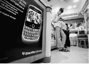 印度海德拉巴的一家手機零售店，售貨員在黑莓手機廣告旁等待顧客。