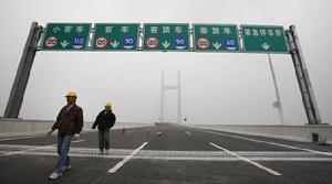 兩名工人正在上海S32申嘉湖高速公路上檢查路面施工。