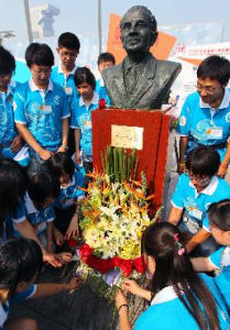 8月8日，志願者向薩馬蘭奇雕塑獻花。
